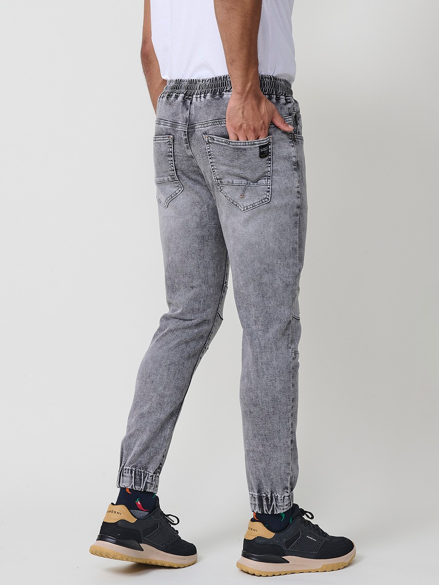 Pantalón jogger de hombre en color denim gris, con bolsillos prácticos y tejido 100% poliéster que aporta resistencia y confort.