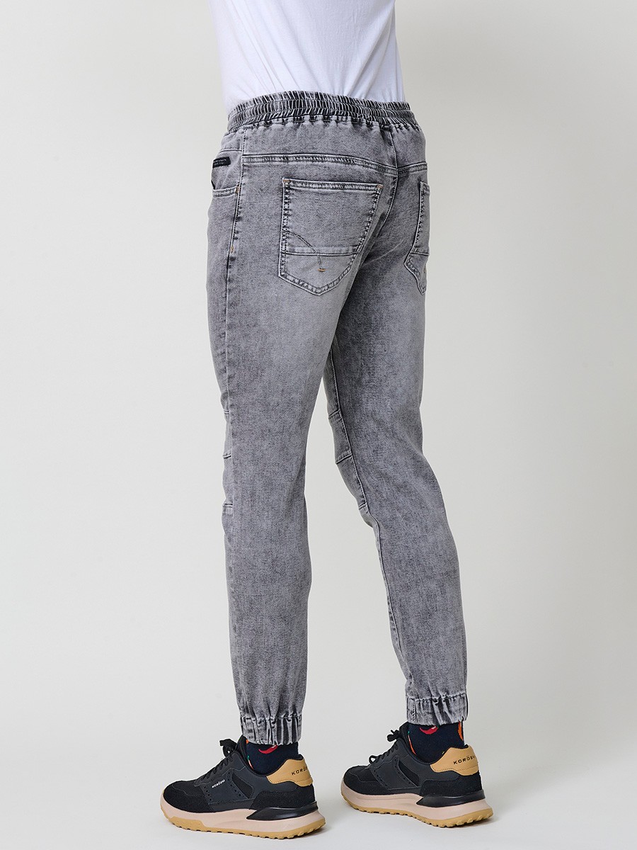 Pantalón jogger de hombre en color denim gris, con bolsillos prácticos y tejido 100% poliéster que aporta resistencia y confort.