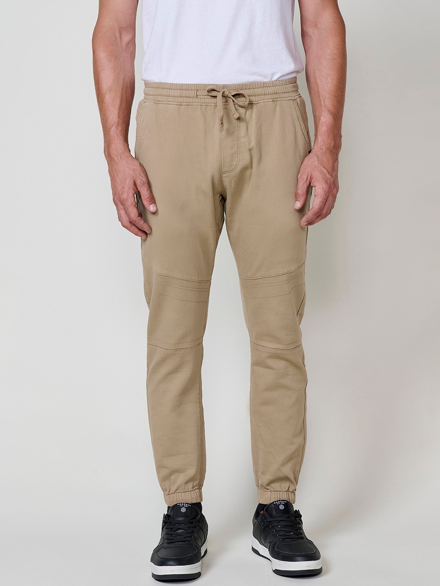 Pantalón jogger de hombre en color beige, con bolsillos laterales, cintura elástica y tejido 100% poliéster cómodo y resistente.