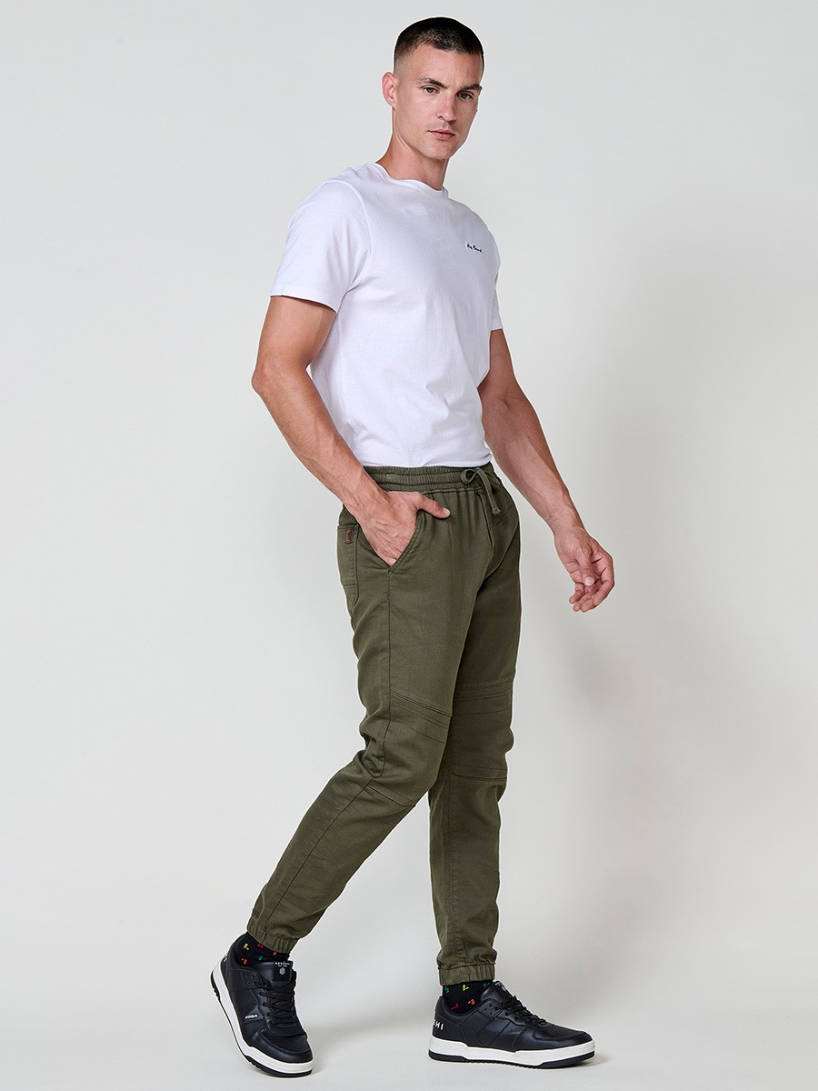 Pantalón jogger de hombre en color kaki, con bolsillos laterales, cintura elástica y tejido 100% poliéster para mayor resistencia y comodidad.