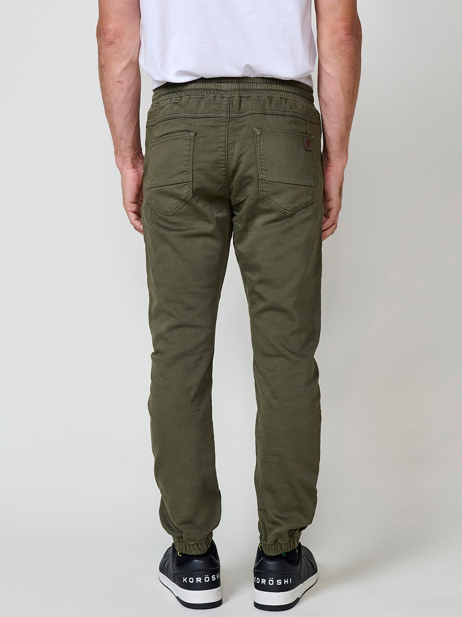 Pantalón jogger de hombre en color kaki, con bolsillos laterales, cintura elástica y tejido 100% poliéster para mayor resistencia y comodidad.