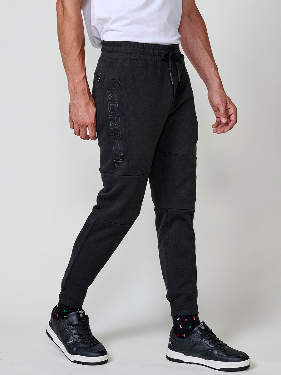 Pantalón jogger de hombre en color negro, con bolsillos laterales, cintura elástica y tejido 100% poliéster resistente y cómodo.