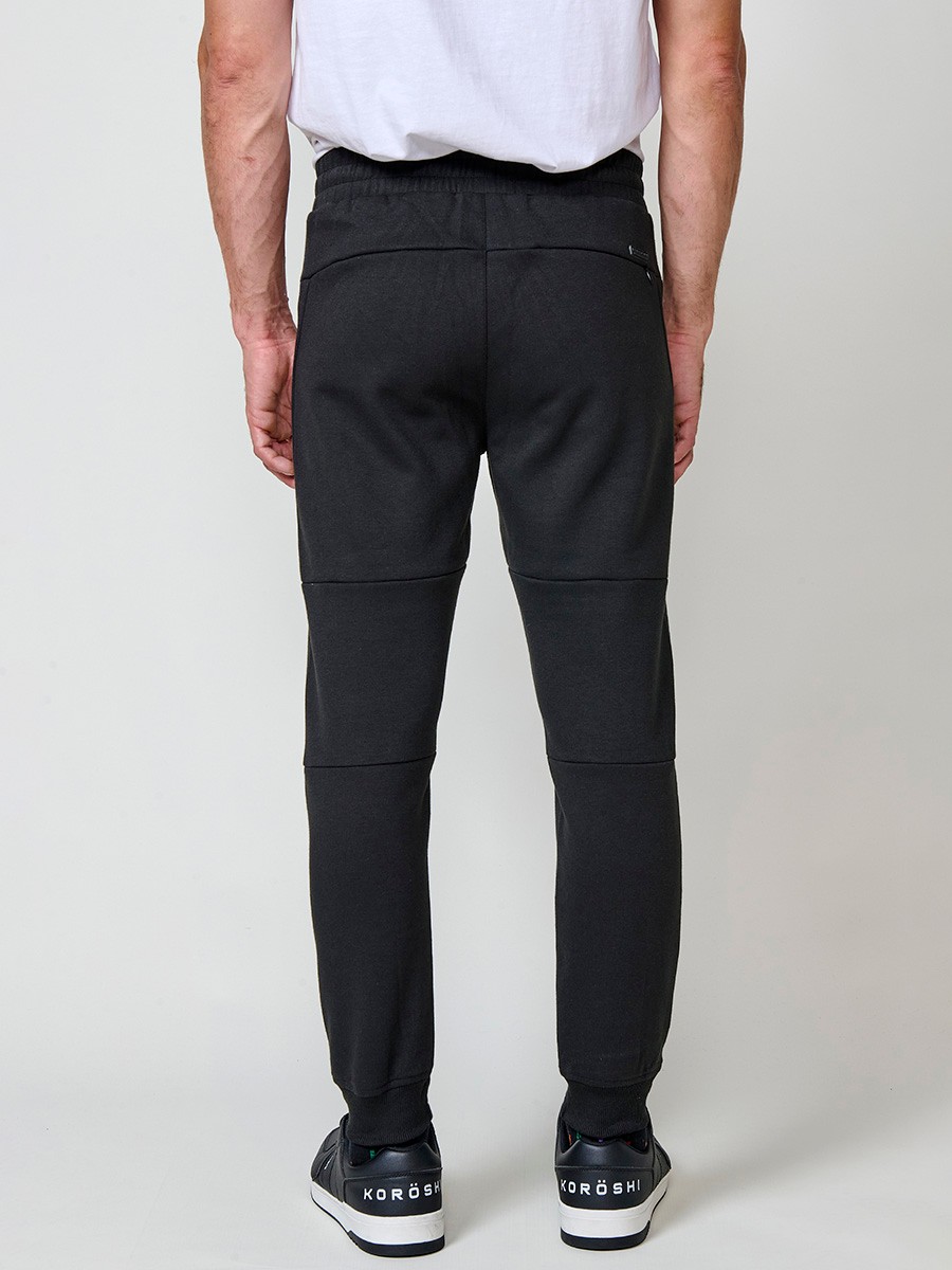 Pantalón jogger de hombre en color negro, con bolsillos laterales, cintura elástica y tejido 100% poliéster resistente y cómodo.