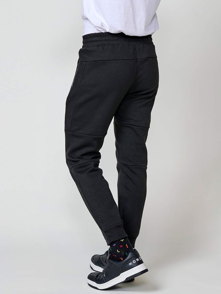 Pantalón jogger de hombre en color negro, con bolsillos laterales, cintura elástica y tejido 100% poliéster resistente y cómodo.