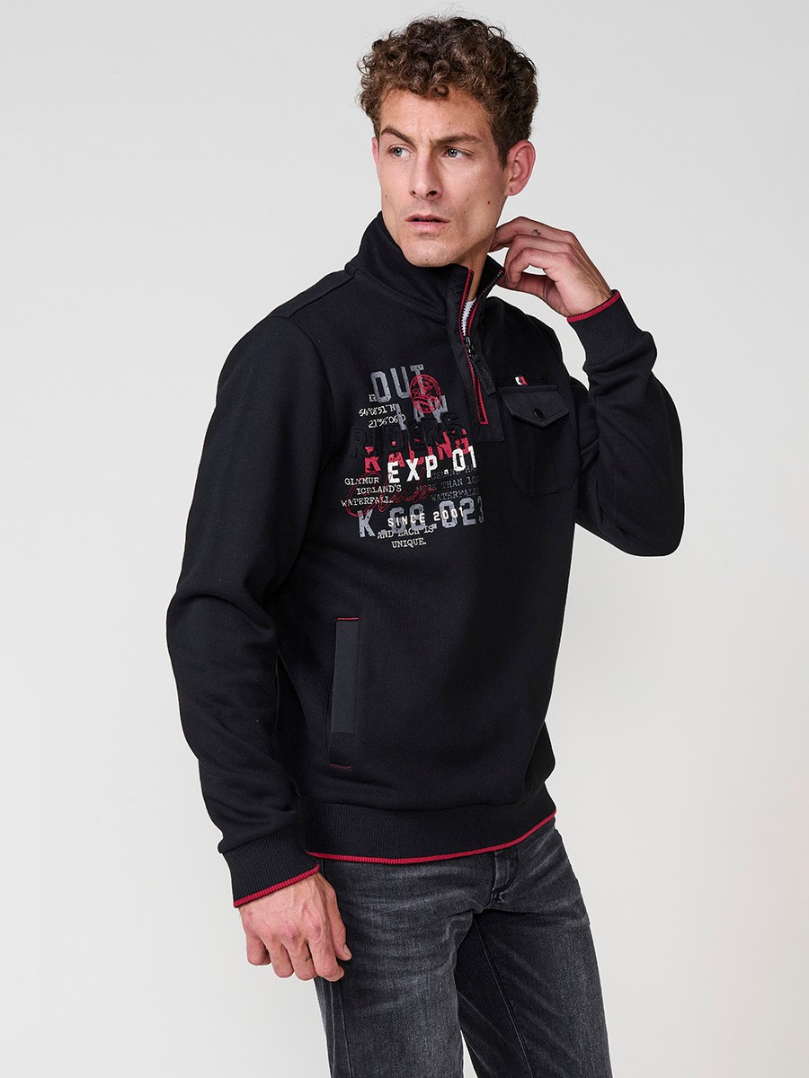 Sudadera de hombre en color negro con cuello alto y cierre de cremallera. Incluye estampado delantero, bolsillo con solapa abotonada y bolsillos laterales.