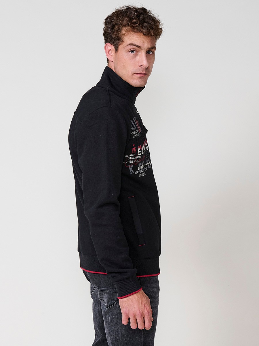 Sudadera de hombre en color negro con cuello alto y cierre de cremallera. Incluye estampado delantero, bolsillo con solapa abotonada y bolsillos laterales.