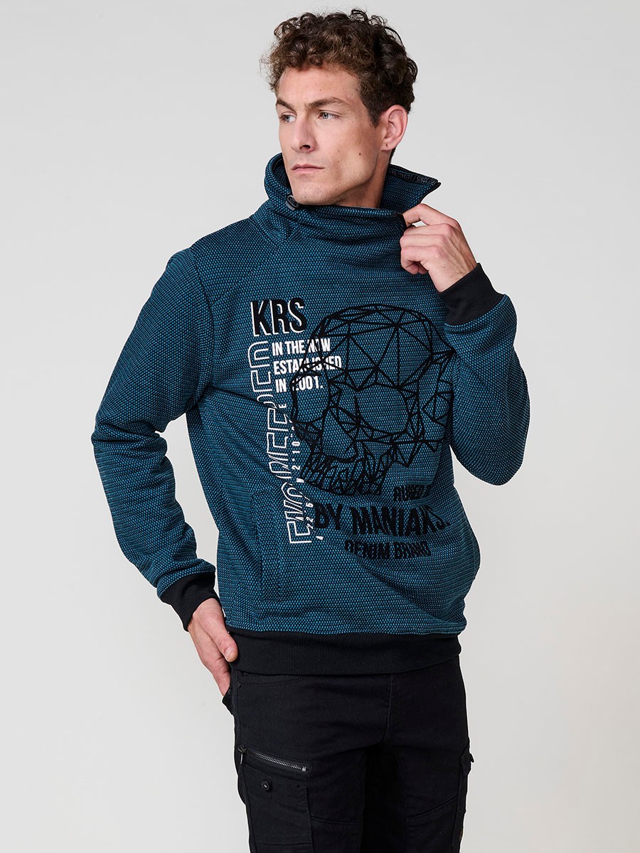 Sudadera de hombre en color petróleo con cuello alto y cremallera. Confeccionada en poliéster 100%, con estampado delantero para un estilo urbano y moderno.