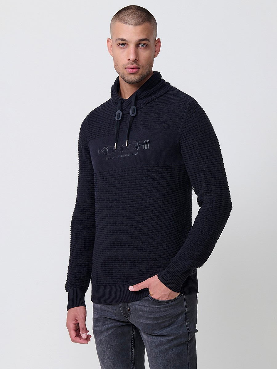 Jersey negro de hombre en tricot con cuello redondo y manga larga. Confección 100% acrílico para un estilo actual y versátil.