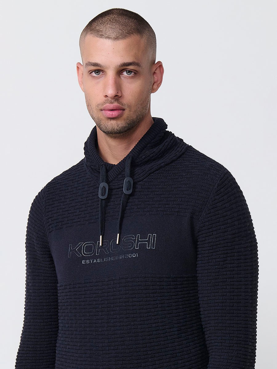 Jersey negro de hombre en tricot con cuello redondo y manga larga. Confección 100% acrílico para un estilo actual y versátil.