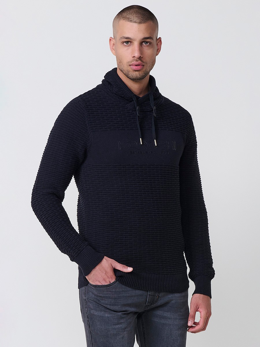 Jersey negro de hombre en tricot con cuello redondo y manga larga. Confección 100% acrílico para un estilo actual y versátil.