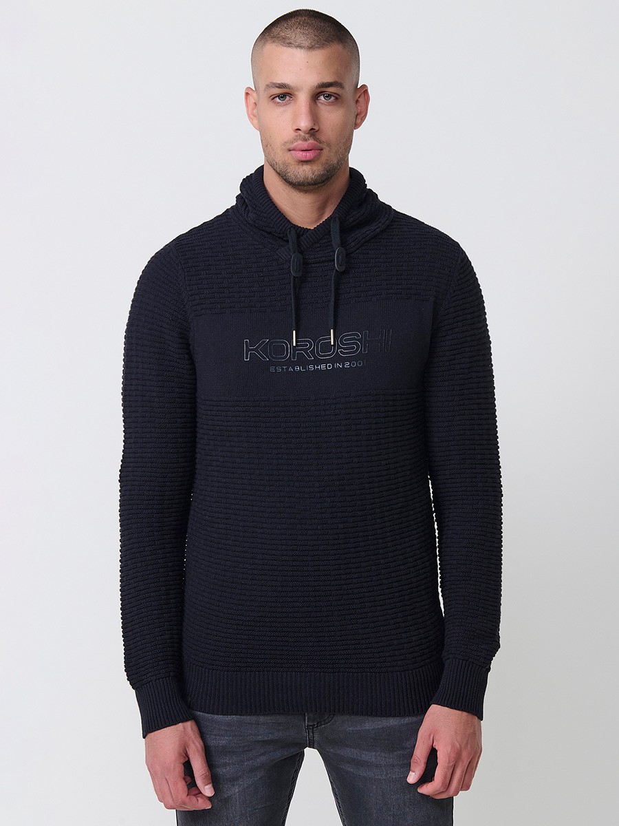 Jersey negro de hombre en tricot con cuello redondo y manga larga. Confección 100% acrílico para un estilo actual y versátil.