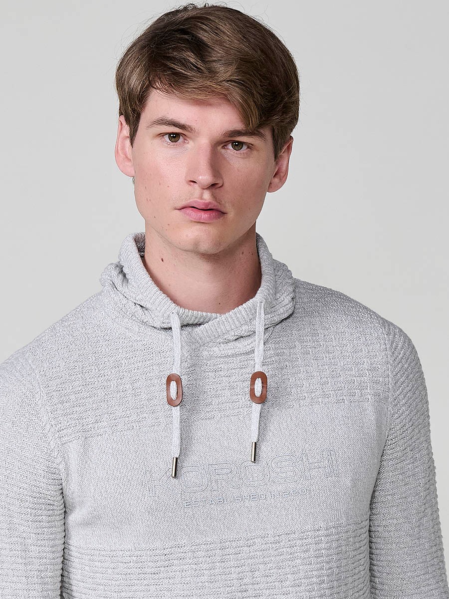 Jersey crudo de hombre en tricot con cuello redondo y manga larga. Confección 100% acrílico para un estilo actual y versátil.