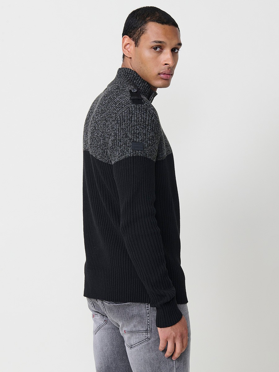 Jersey negro de hombre en tricot con cuello redondo y manga larga. Confección 100% acrílico para un estilo actual y versátil.