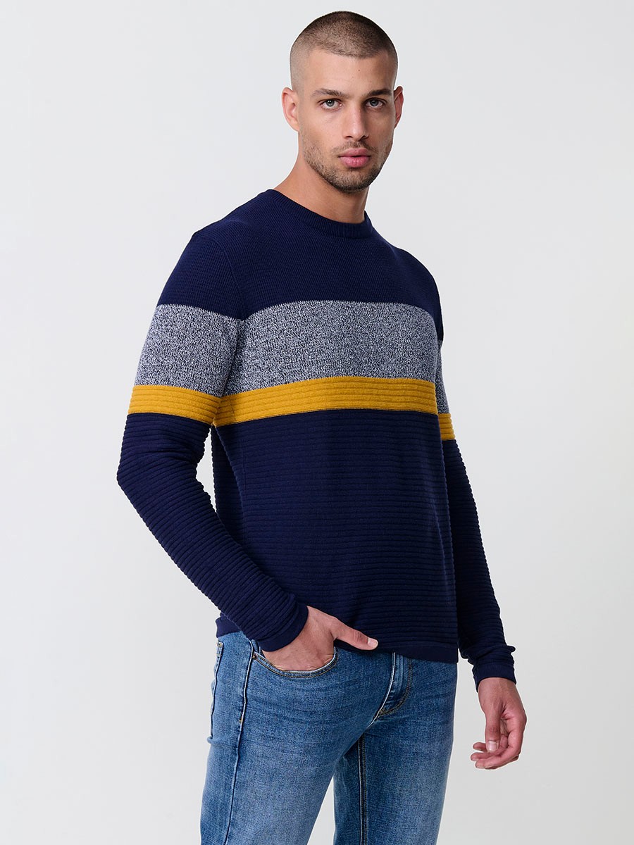 Jersey mostaza de hombre en tricot con cuello redondo y manga larga. 100% acrílico, ligero y versátil para un estilo urbano y moderno.