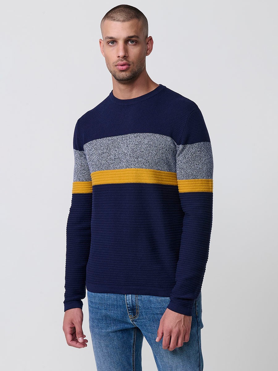 Jersey mostaza de hombre en tricot con cuello redondo y manga larga. 100% acrílico, ligero y versátil para un estilo urbano y moderno.