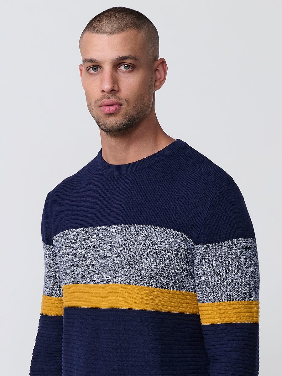 Jersey mostaza de hombre en tricot con cuello redondo y manga larga. 100% acrílico, ligero y versátil para un estilo urbano y moderno.