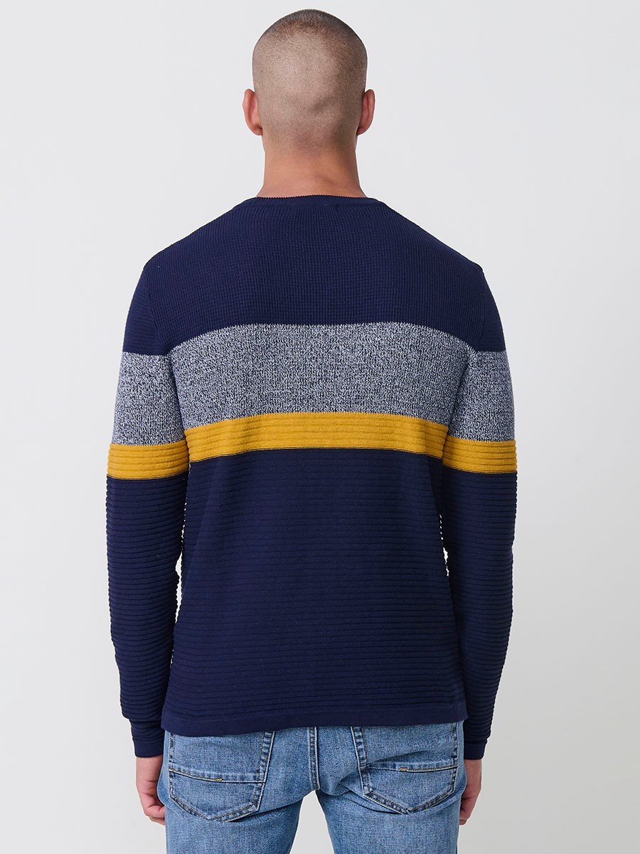 Jersey mostaza de hombre en tricot con cuello redondo y manga larga. 100% acrílico, ligero y versátil para un estilo urbano y moderno.
