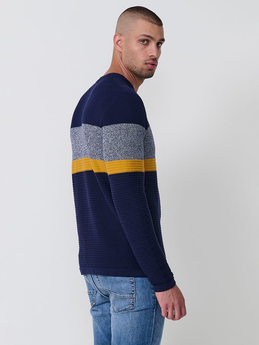 Jersey mostaza de hombre en tricot con cuello redondo y manga larga. 100% acrílico, ligero y versátil para un estilo urbano y moderno.