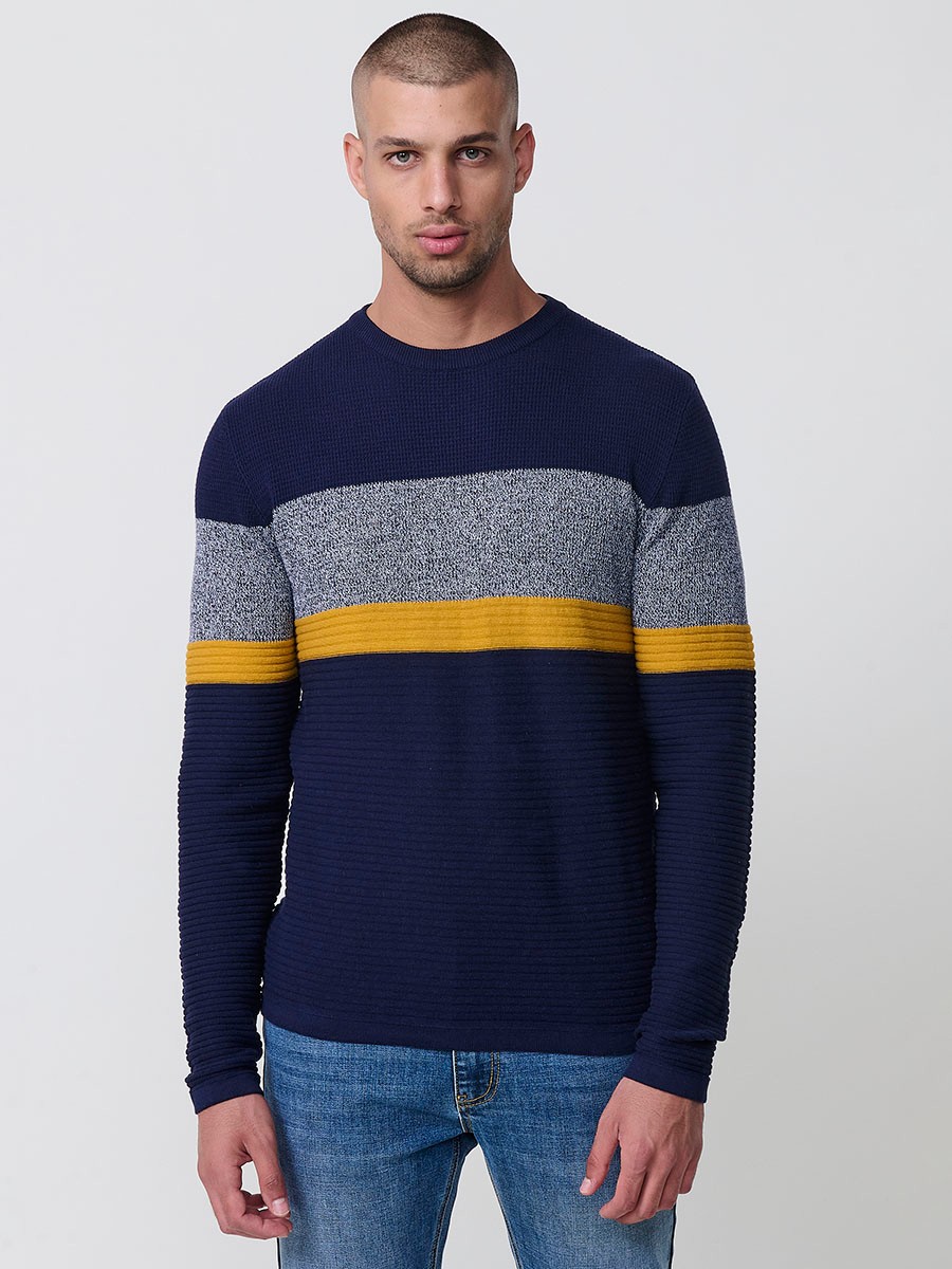 Jersey mostaza de hombre en tricot con cuello redondo y manga larga. 100% acrílico, ligero y versátil para un estilo urbano y moderno.