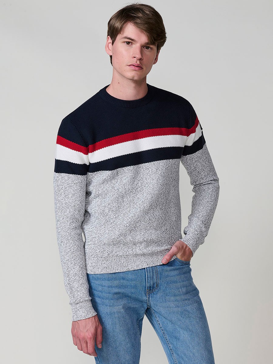 Jersey gris de hombre en tricot con cuello redondo y manga larga. 100% acrílico para un estilo moderno, cómodo y versátil.