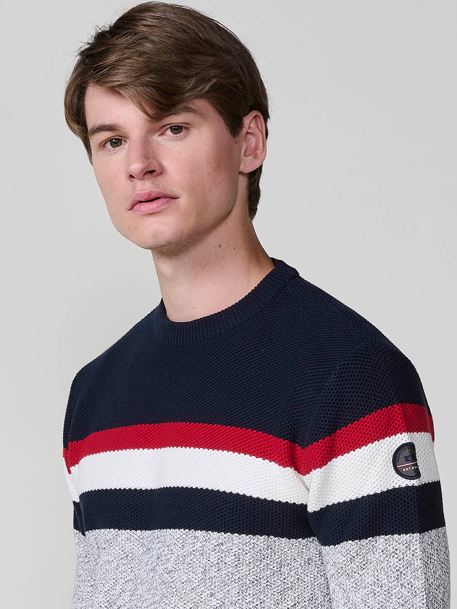 Jersey gris de hombre en tricot con cuello redondo y manga larga. 100% acrílico para un estilo moderno, cómodo y versátil.