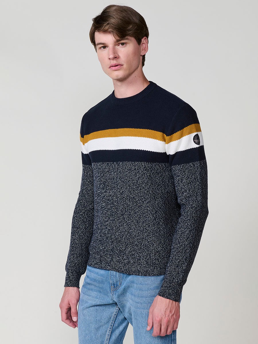 Jersey navy de hombre en tricot con cuello redondo y manga larga. Confección 100% acrílico para un estilo moderno, versátil y cómodo.
