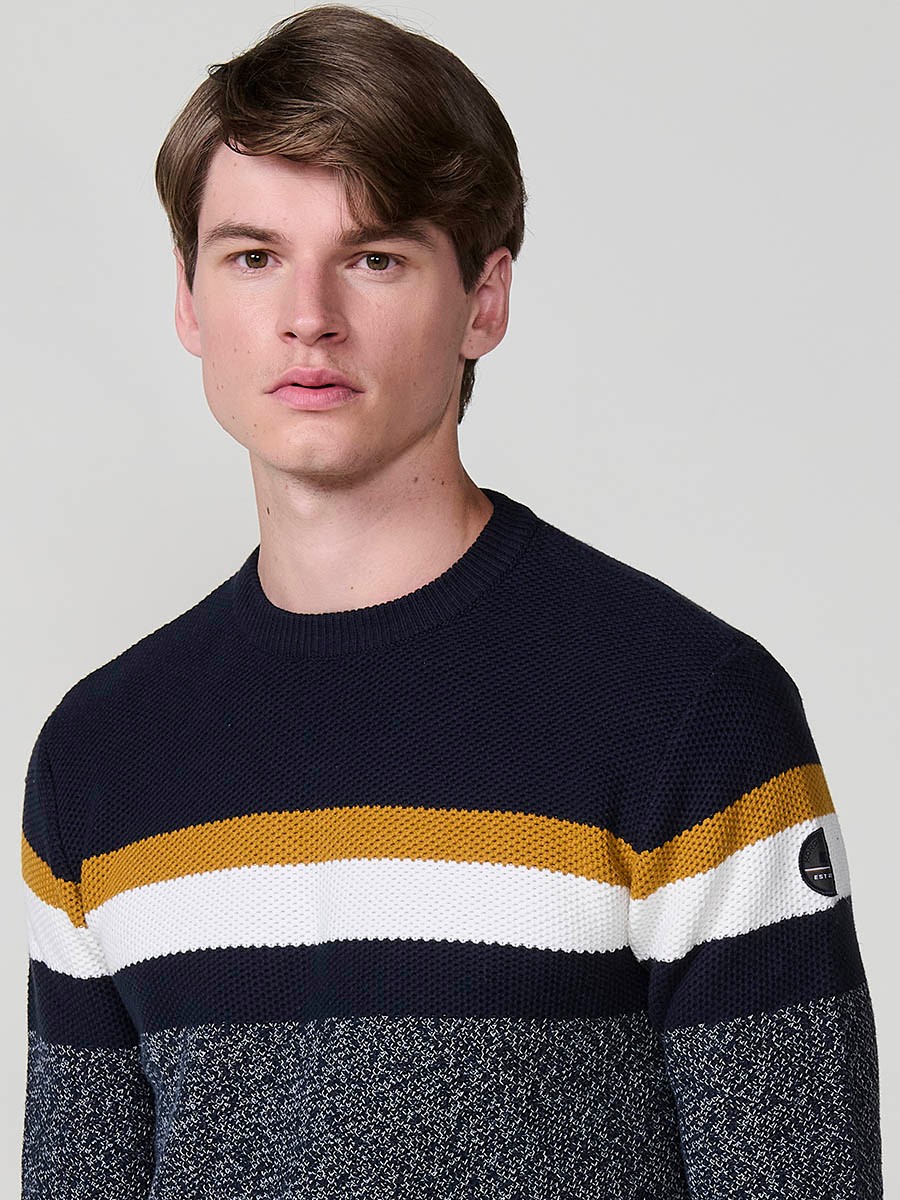 Jersey navy de hombre en tricot con cuello redondo y manga larga. Confección 100% acrílico para un estilo moderno, versátil y cómodo.