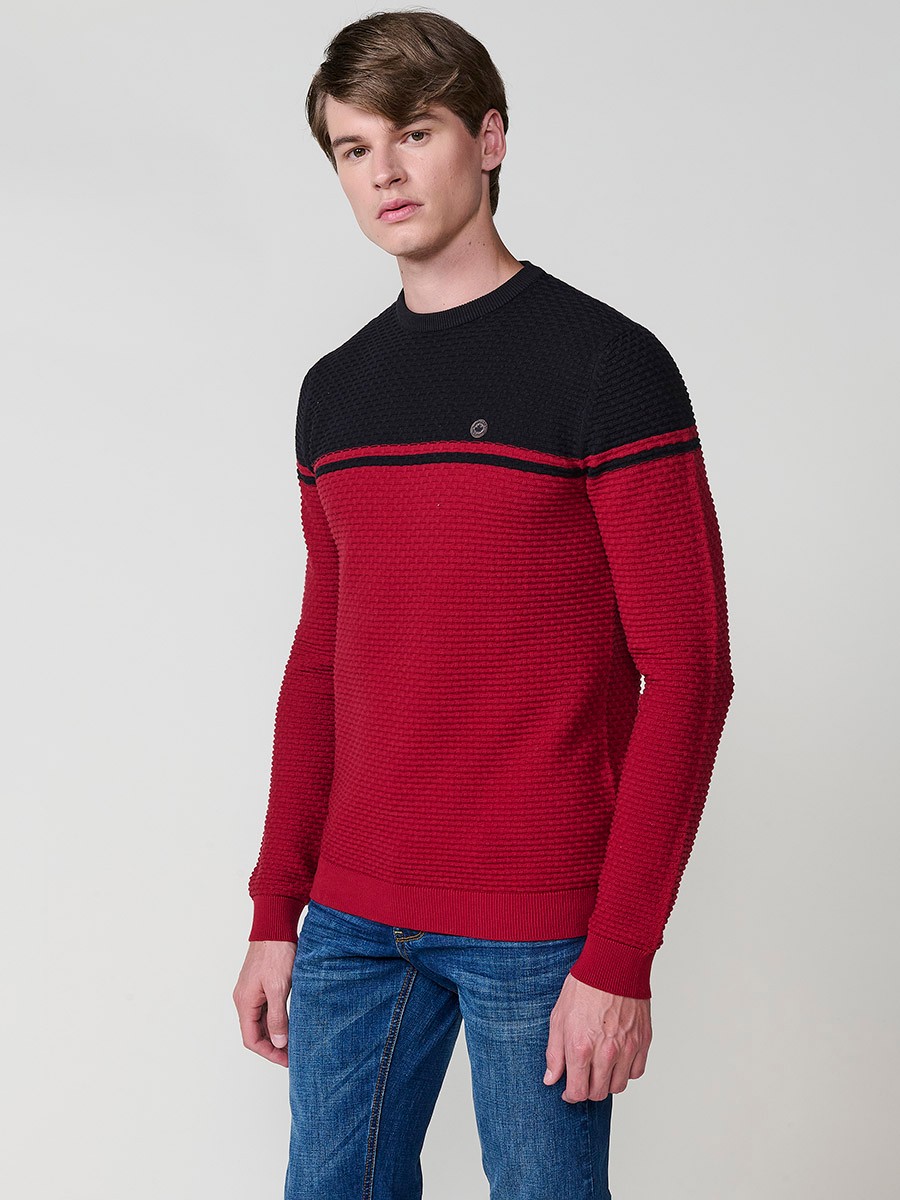Jersey rojo de hombre en tricot con cuello redondo y manga larga. Confección 100% acrílico para un estilo moderno y atemporal.