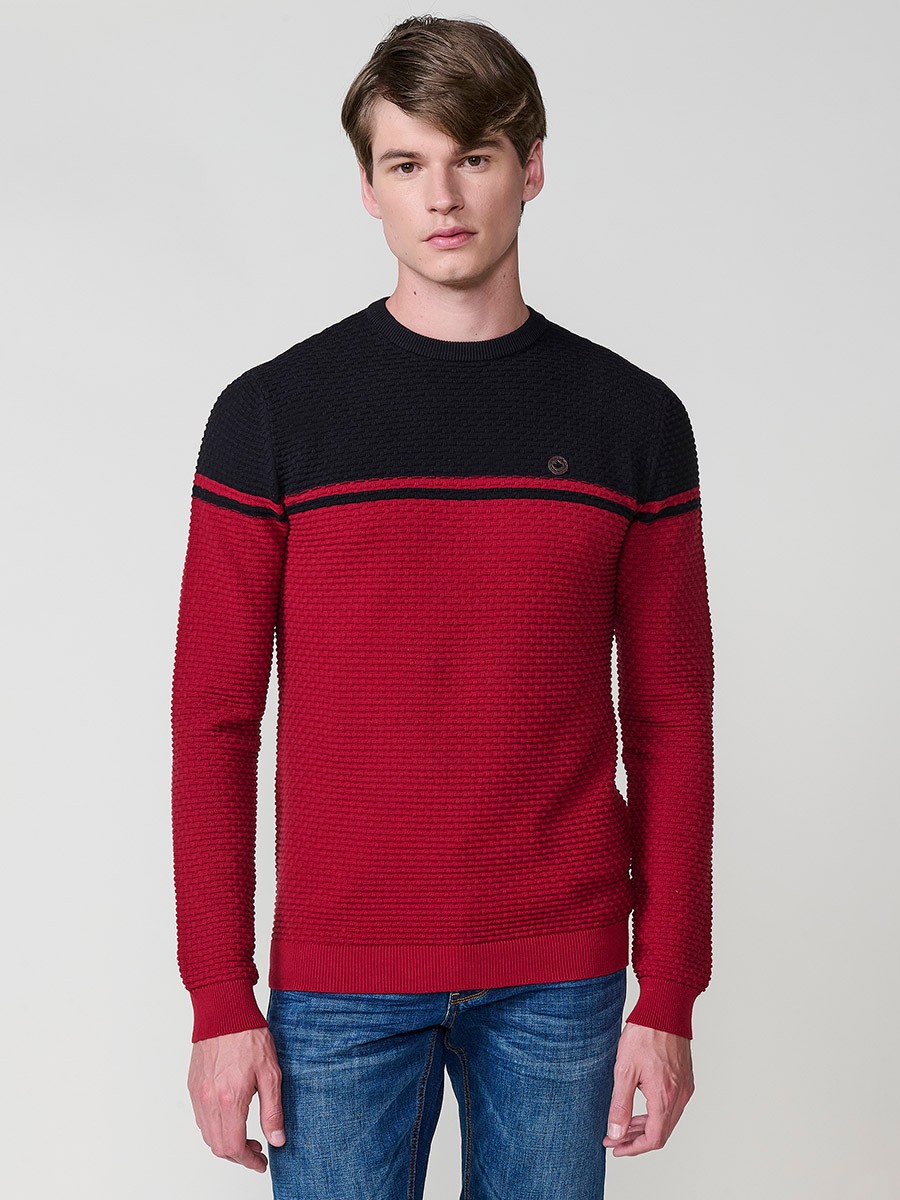 Jersey rojo de hombre en tricot con cuello redondo y manga larga. Confección 100% acrílico para un estilo moderno y atemporal.