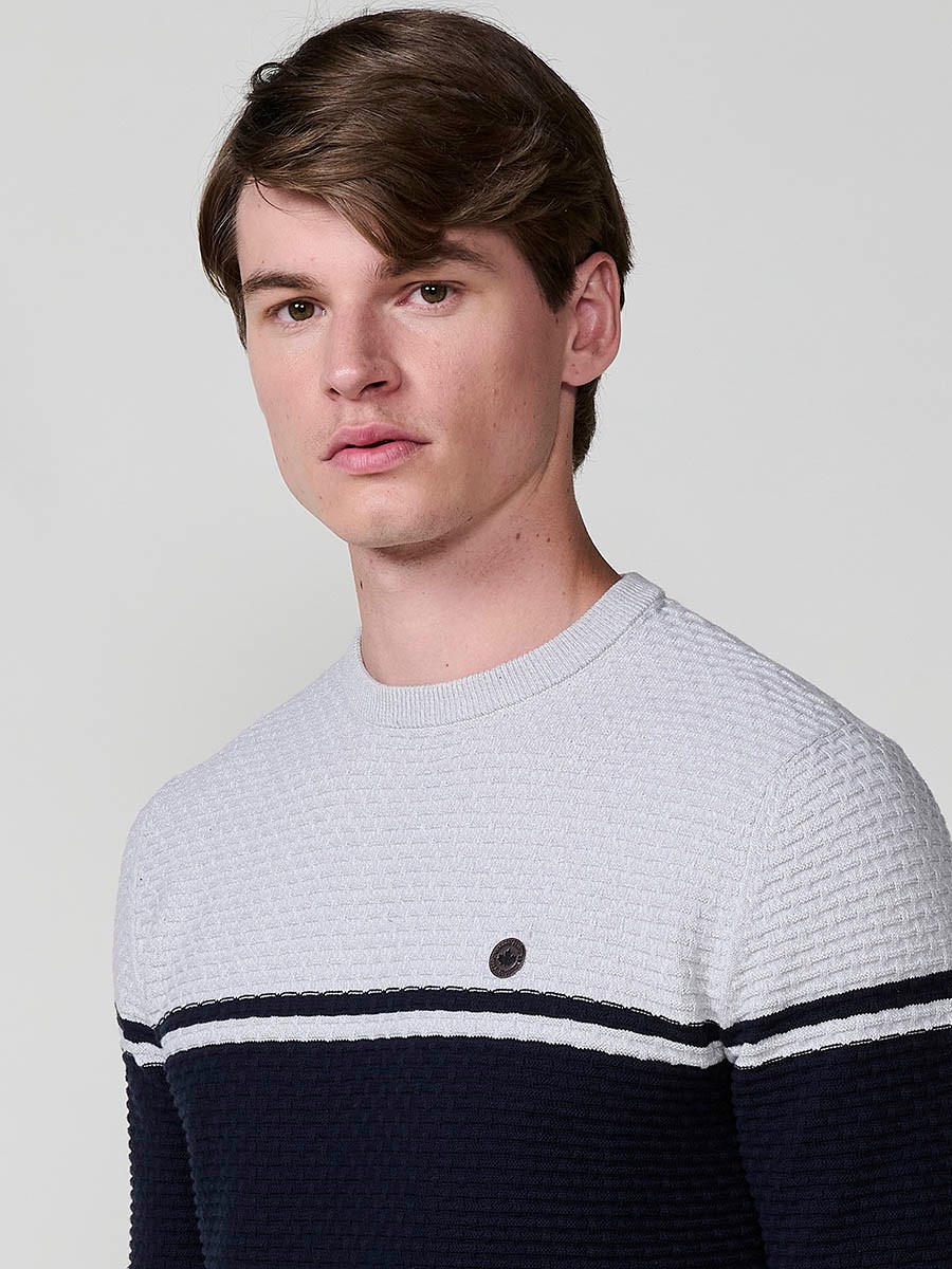 Jersey navy de hombre en tricot con cuello redondo y manga larga. Confección 100% acrílico, cómodo y versátil para cualquier temporada.