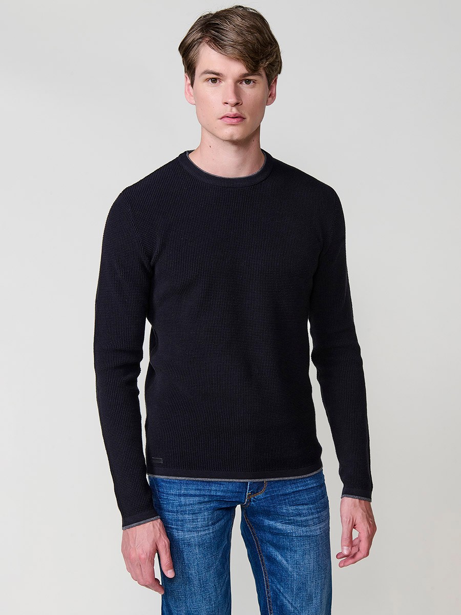 Jersey negro de hombre en tricot con cuello redondo y manga larga. Tejido 100% acrílico, cómodo y versátil para cualquier temporada.