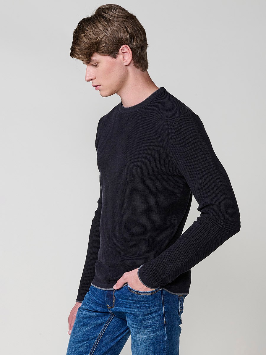 Jersey negro de hombre en tricot con cuello redondo y manga larga. Tejido 100% acrílico, cómodo y versátil para cualquier temporada.