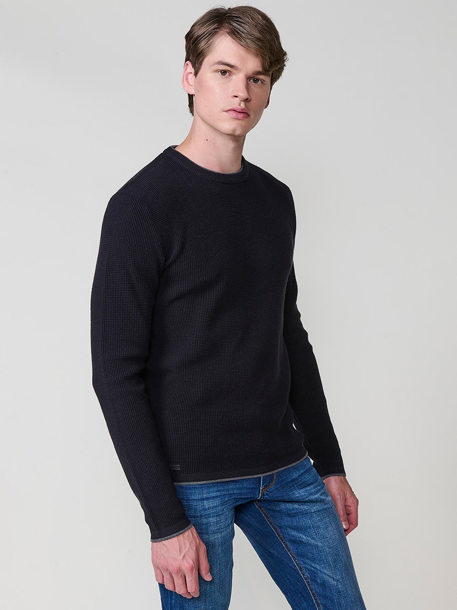 Jersey negro de hombre en tricot con cuello redondo y manga larga. Tejido 100% acrílico, cómodo y versátil para cualquier temporada.