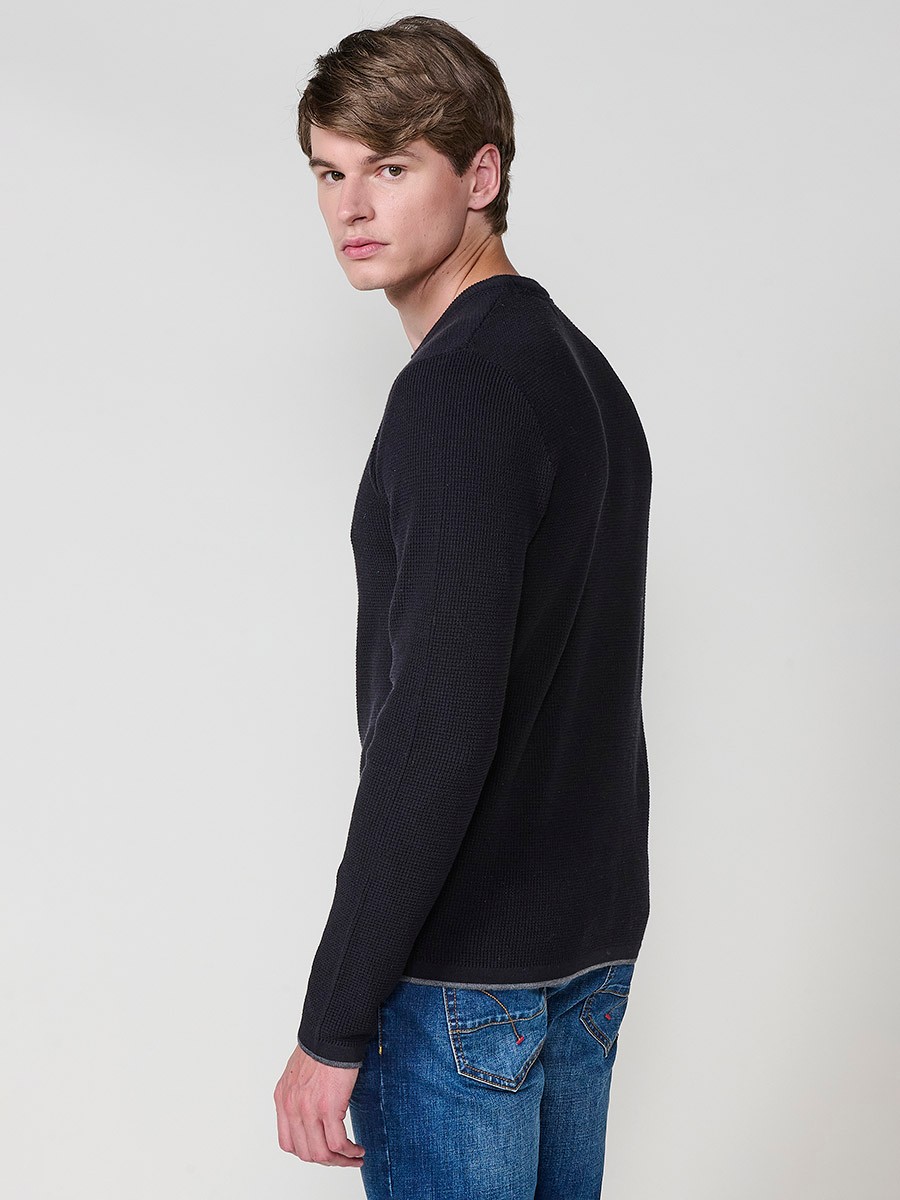 Jersey negro de hombre en tricot con cuello redondo y manga larga. Tejido 100% acrílico, cómodo y versátil para cualquier temporada.