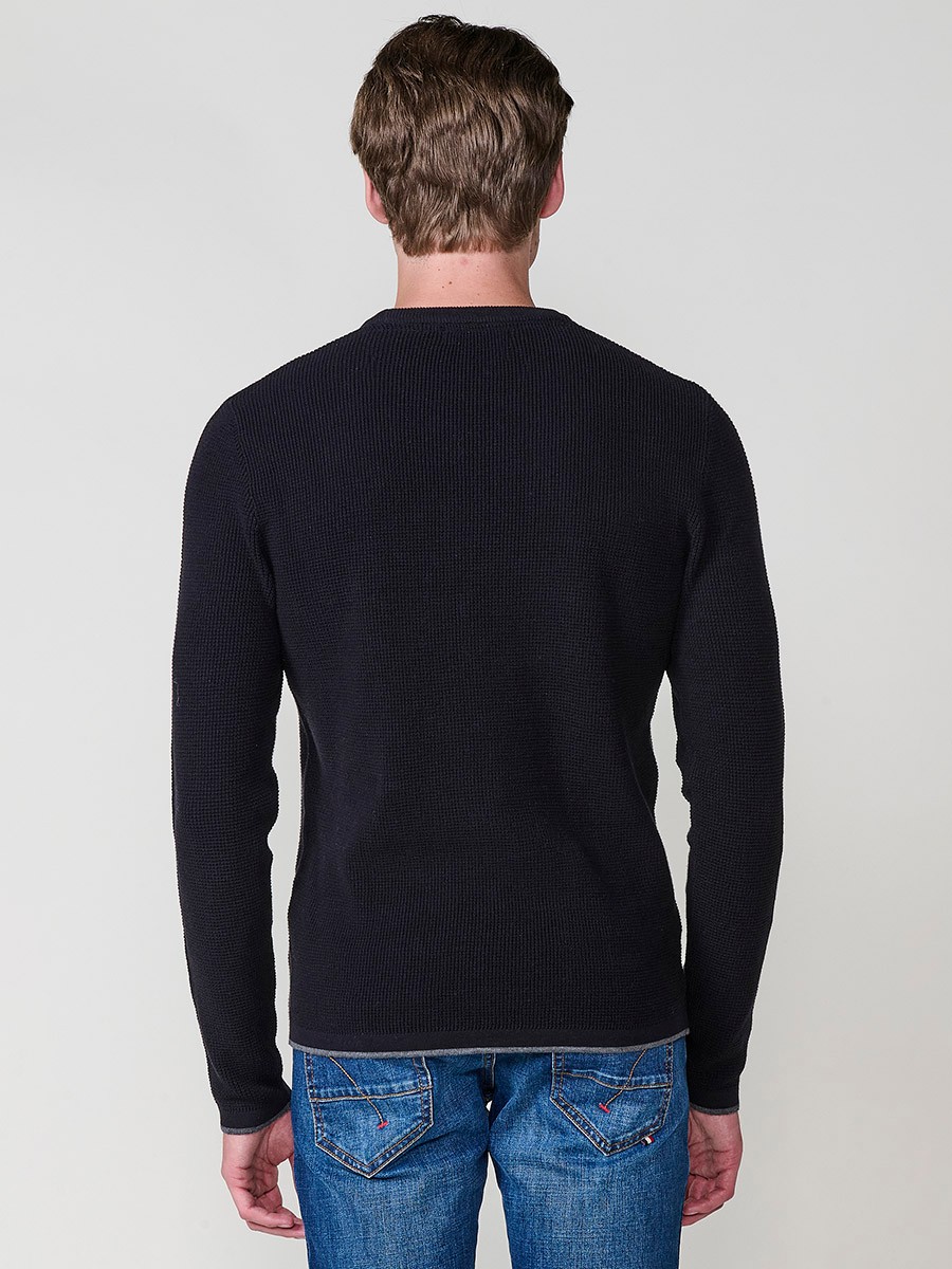 Jersey negro de hombre en tricot con cuello redondo y manga larga. Tejido 100% acrílico, cómodo y versátil para cualquier temporada.
