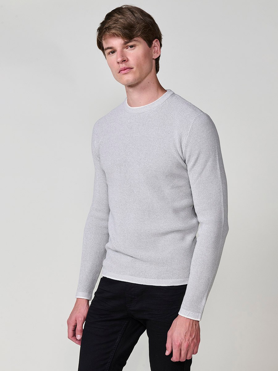 Jersey crudo de hombre en tricot con cuello redondo y manga larga. Tejido 100% acrílico, ligero, cómodo y atemporal.