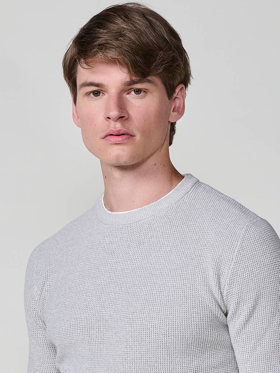 Jersey crudo de hombre en tricot con cuello redondo y manga larga. Tejido 100% acrílico, ligero, cómodo y atemporal.