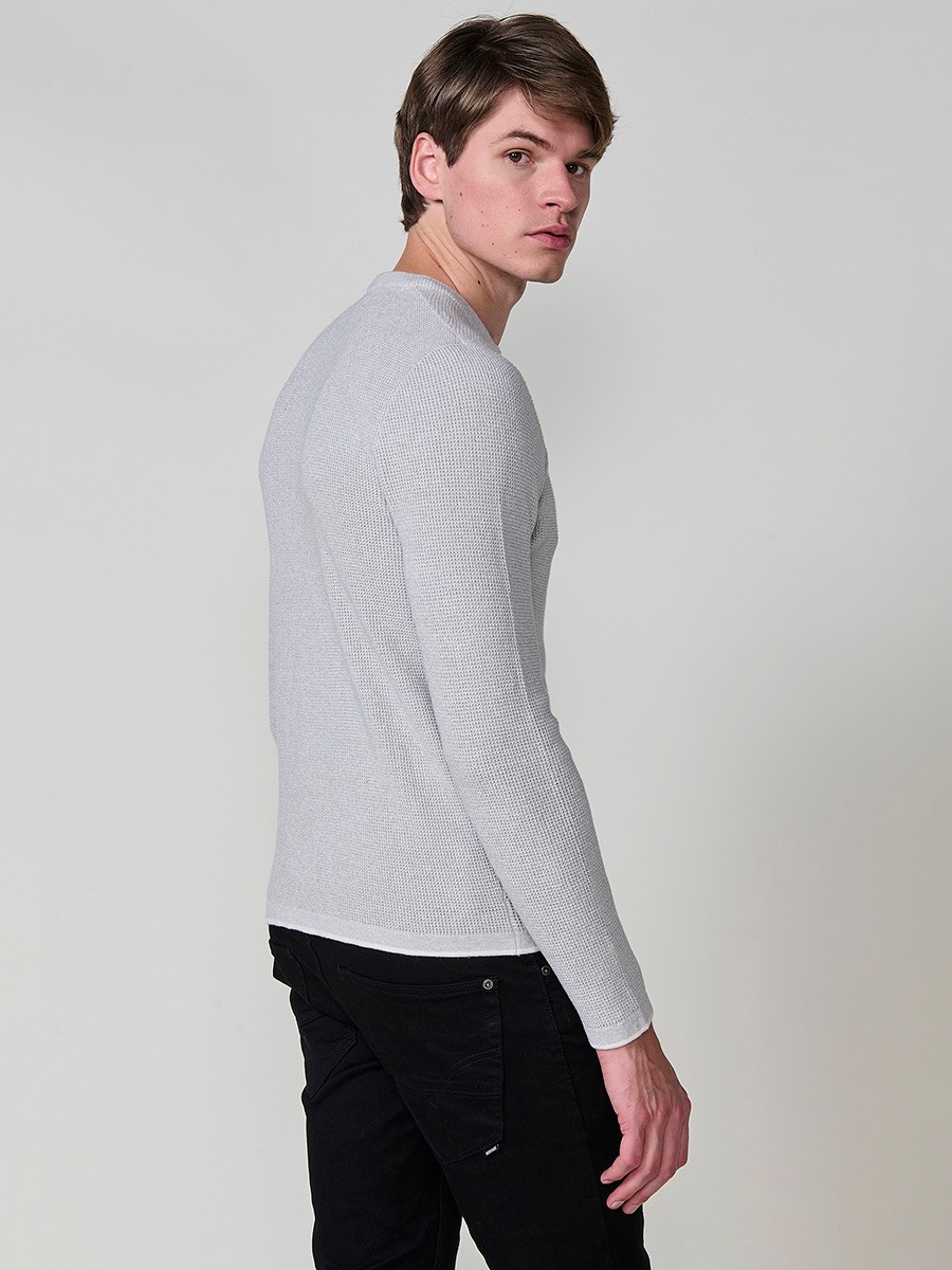Jersey crudo de hombre en tricot con cuello redondo y manga larga. Tejido 100% acrílico, ligero, cómodo y atemporal.
