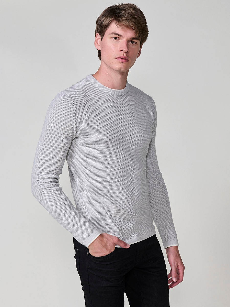 Jersey crudo de hombre en tricot con cuello redondo y manga larga. Tejido 100% acrílico, ligero, cómodo y atemporal.