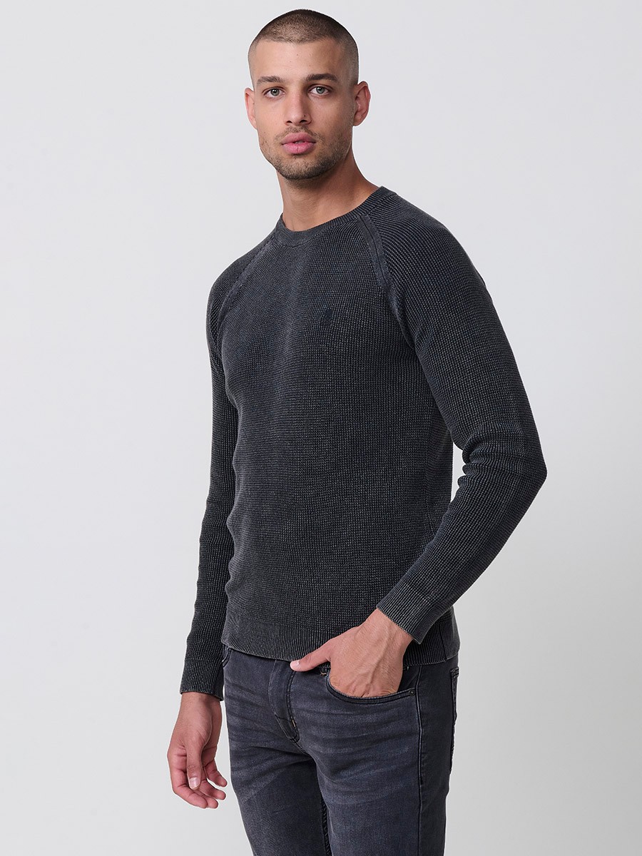Jersey negro de hombre en tricot con cuello redondo y manga larga. Tejido 100% acrílico, cómodo y atemporal para todas las temporadas.