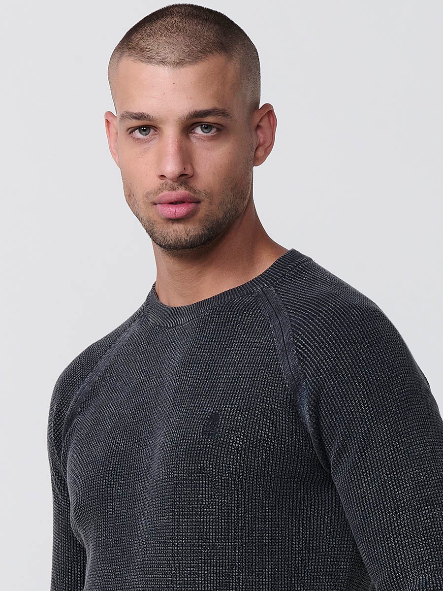 Jersey negro de hombre en tricot con cuello redondo y manga larga. Tejido 100% acrílico, cómodo y atemporal para todas las temporadas.