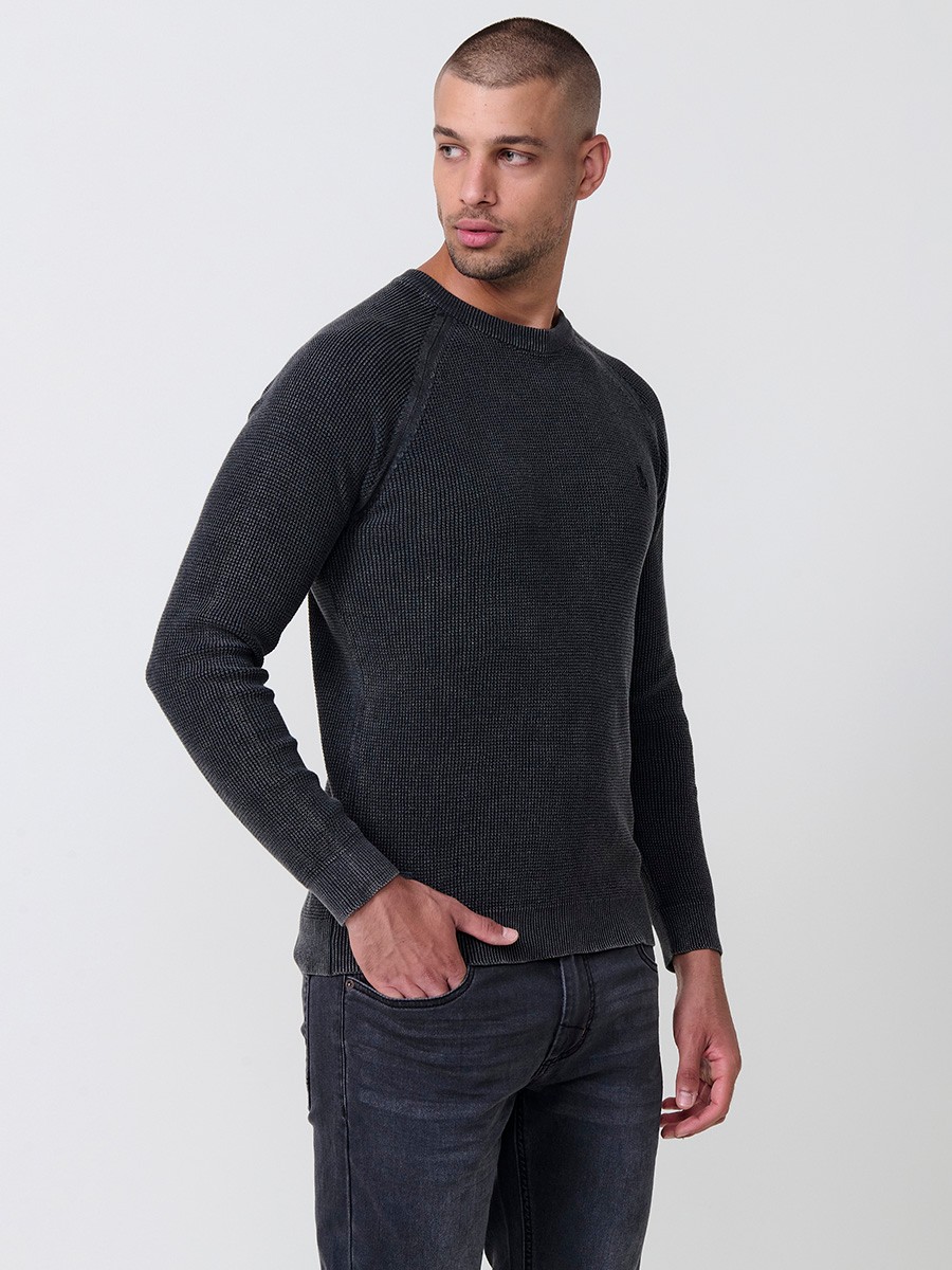 Jersey negro de hombre en tricot con cuello redondo y manga larga. Tejido 100% acrílico, cómodo y atemporal para todas las temporadas.