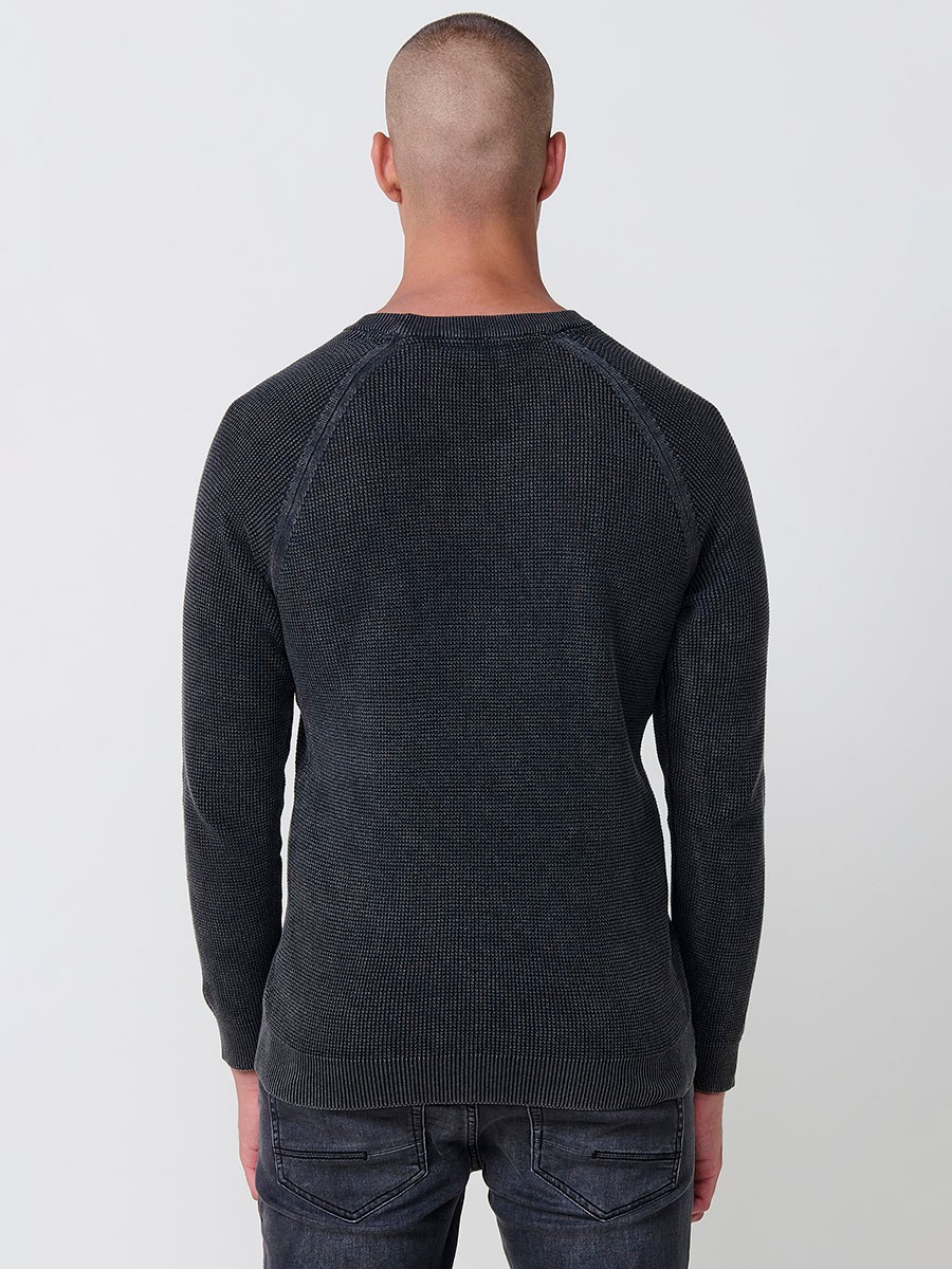 Jersey negro de hombre en tricot con cuello redondo y manga larga. Tejido 100% acrílico, cómodo y atemporal para todas las temporadas.