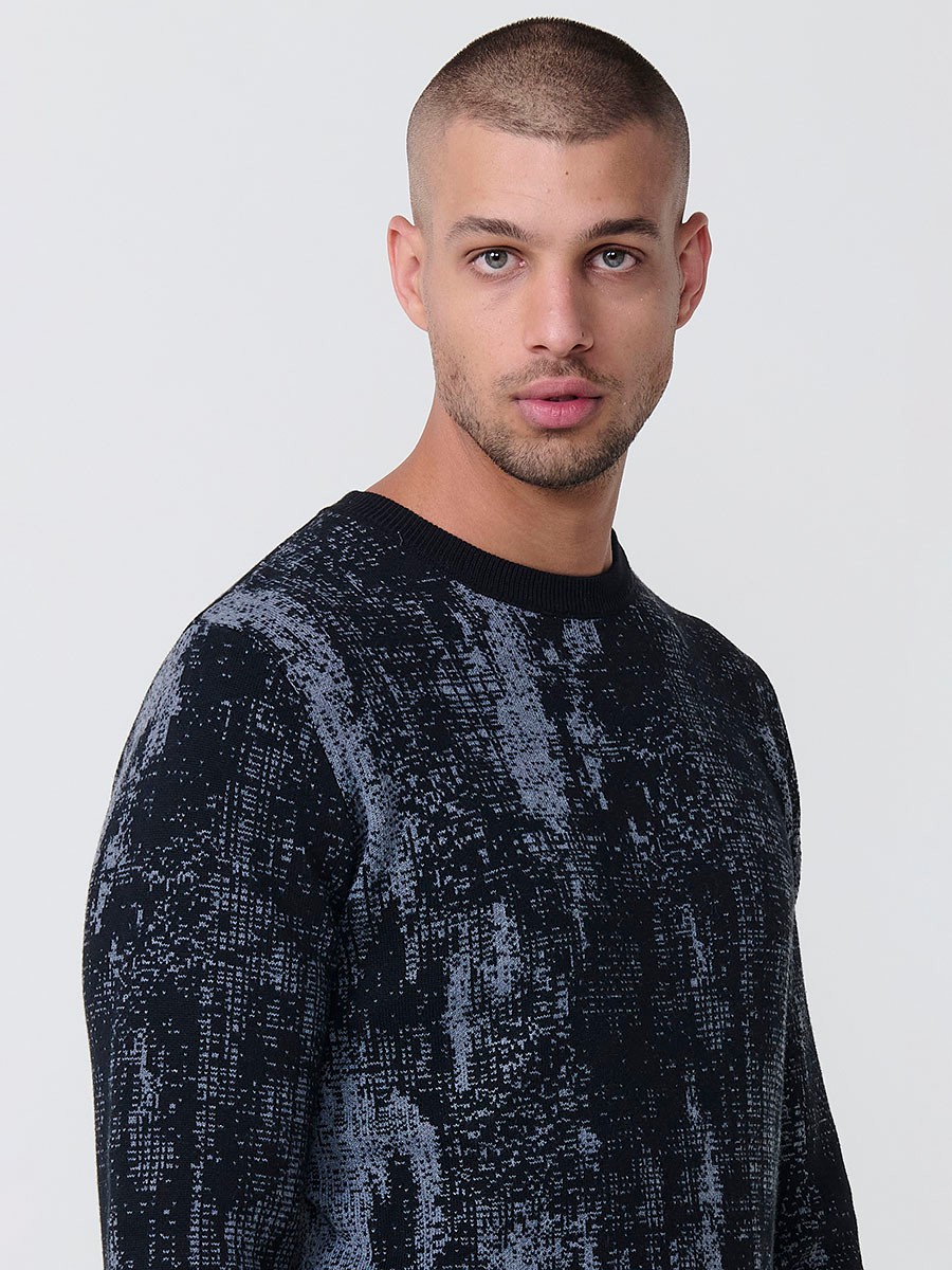 Jersey jaspeado negro de hombre en tricot con cuello redondo y manga larga. Tejido mezcla de algodón y poliéster, cómodo y moderno.