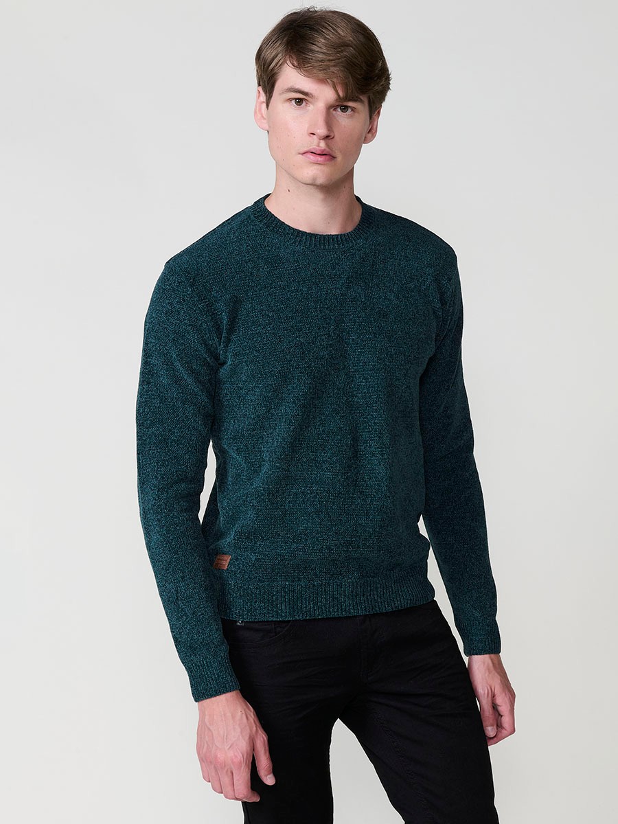 Jersey verde de hombre en tricot con cuello redondo, manga larga y acabados en rib. Tejido mezcla de poliéster y poliamida, cómodo y moderno.
