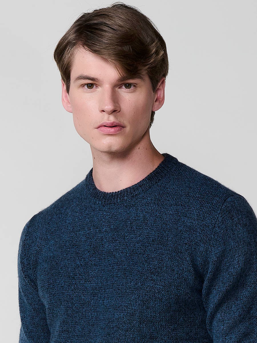 Jersey azul de hombre en tricot con cuello redondo y manga larga. Tejido mezcla de acrílico, poliamida y elastano, cómodo y moderno.