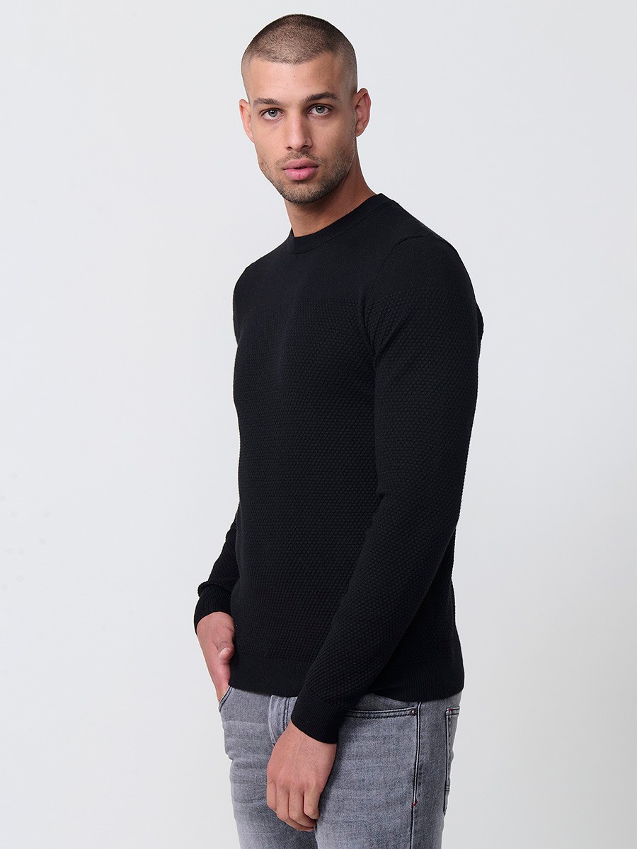 Jersey negro de hombre en tricot con cuello redondo y manga larga. Mezcla de viscosa, poliamida y poliéster, suave y versátil.