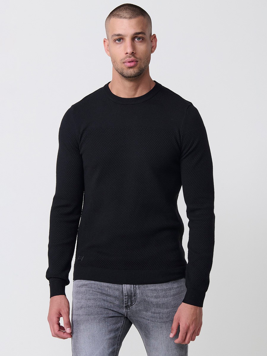 Jersey negro de hombre en tricot con cuello redondo y manga larga. Mezcla de viscosa, poliamida y poliéster, suave y versátil.