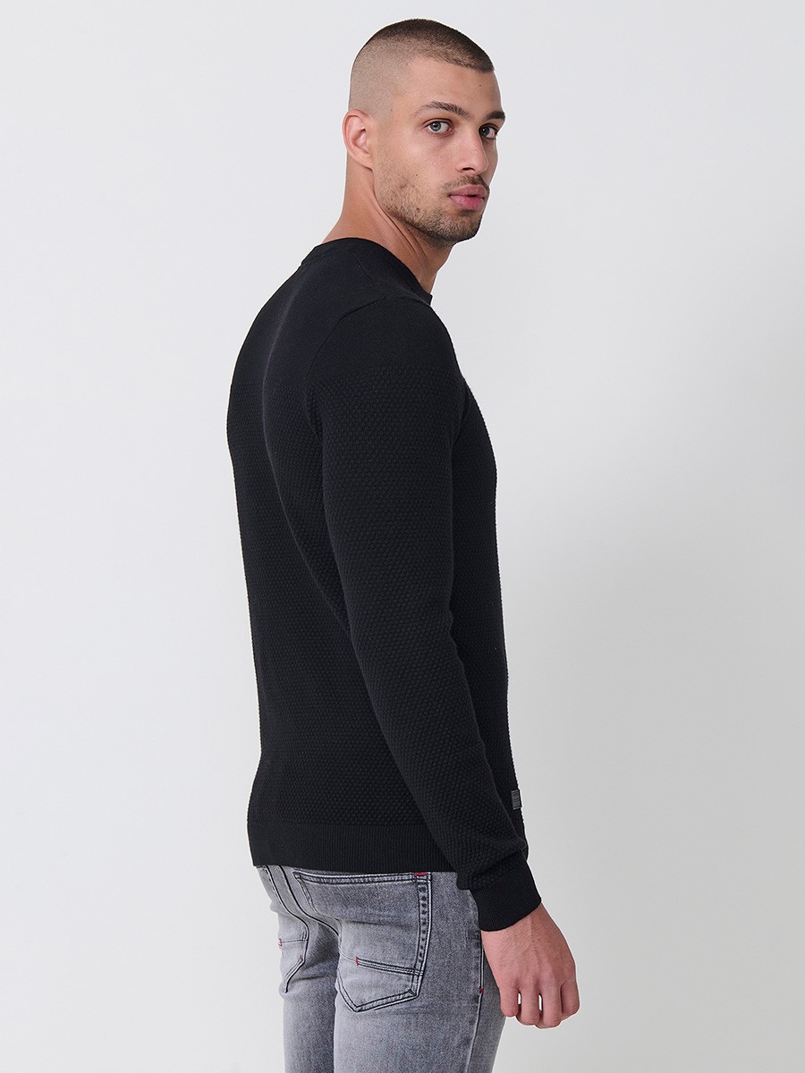 Jersey negro de hombre en tricot con cuello redondo y manga larga. Mezcla de viscosa, poliamida y poliéster, suave y versátil.