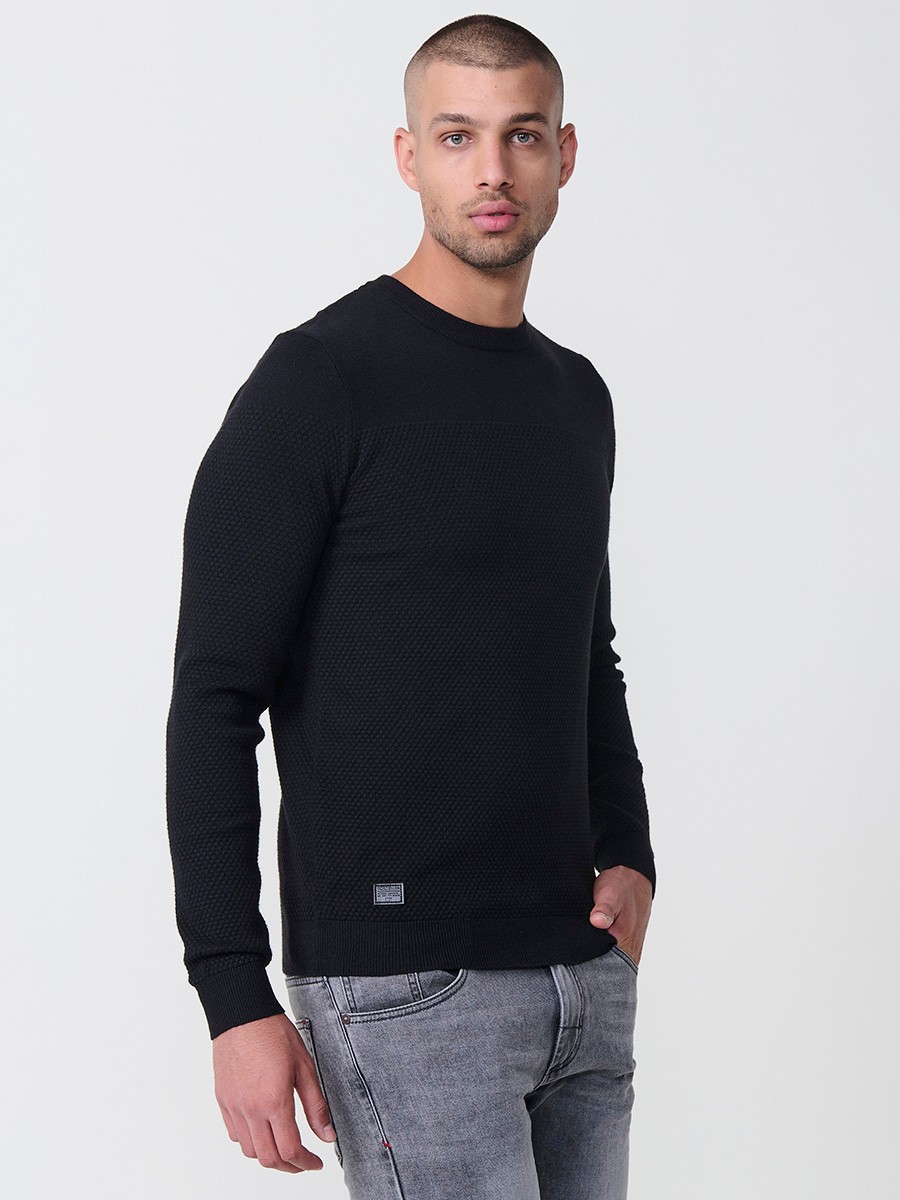 Jersey negro de hombre en tricot con cuello redondo y manga larga. Mezcla de viscosa, poliamida y poliéster, suave y versátil.
